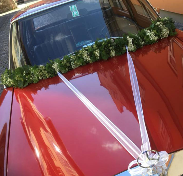 roter Mercedes mit floralem Hochzeitsschmuck