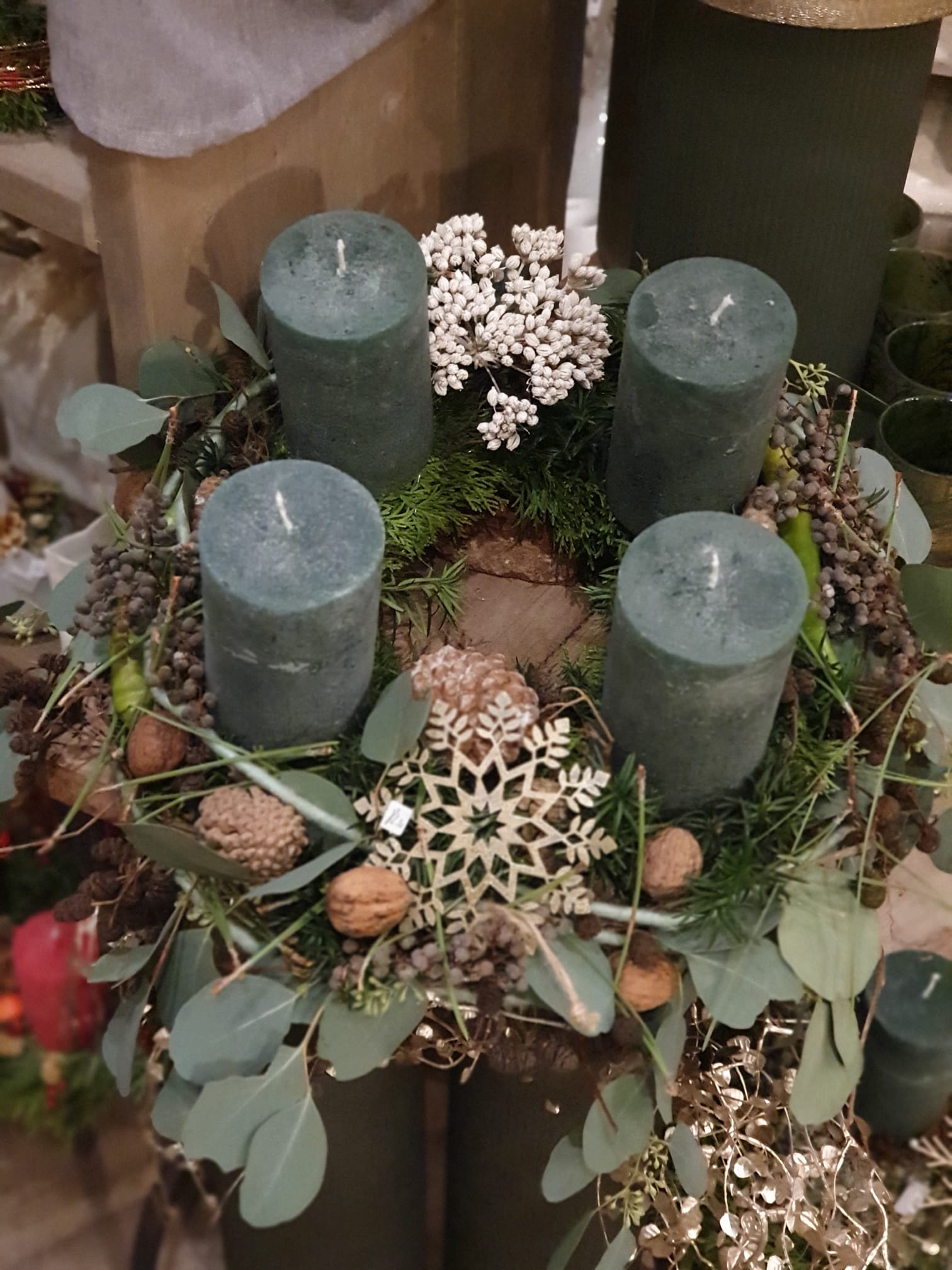 Adventskranz grün mit Eukalyptusblättern Nüssen und grünen Kerzen